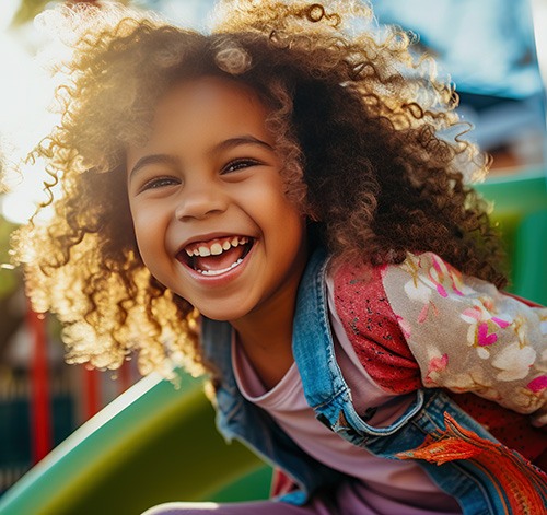 Child smiling while playing on playground