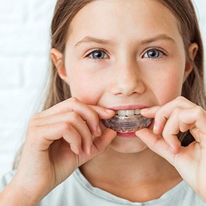 Closeup of child putting mouthguard in