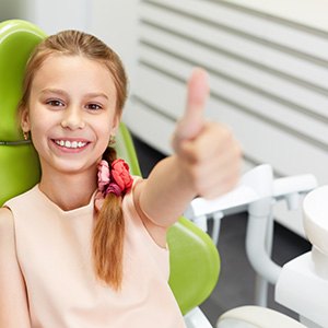 Child giving thumbs up in dentist's office