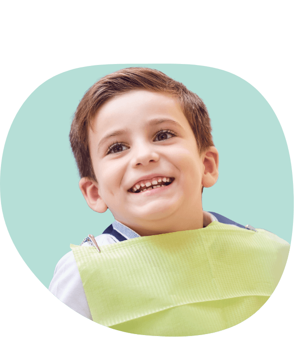 Young boy wearing dental bib during preventive dentistry checkup