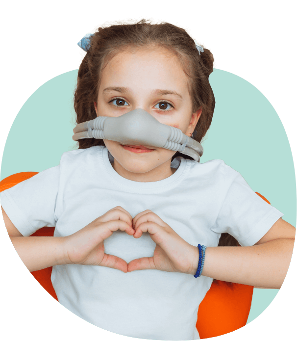 Girl making heart shape with her hands while wearing mask for sedation dentistry for kids