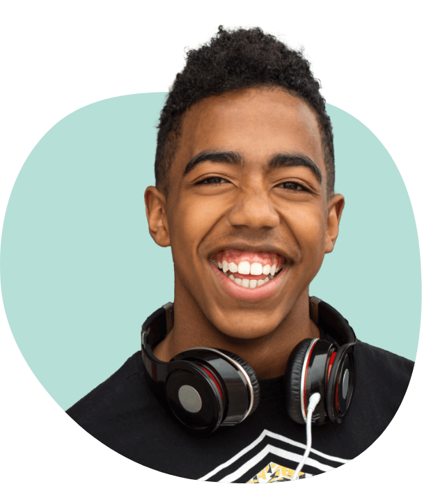 Young man with headphones smiling after seeing dentist for teens in South Portland and Auburn