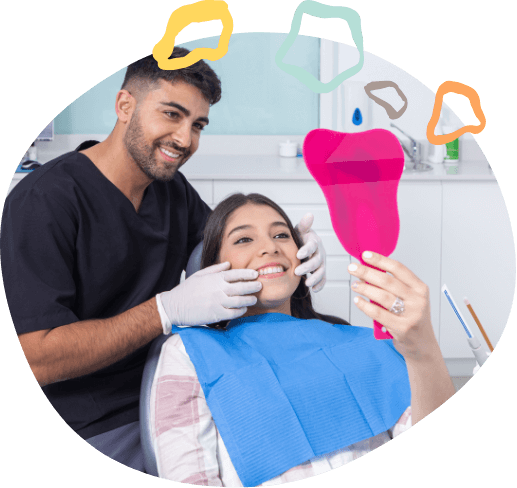 Teenage girl in dental chair looking at her smile in mirror