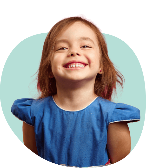 Young girl in blue blouse smiling after visiting pediatric dentist in South Portland and Auburn