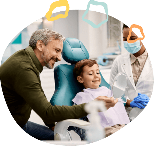 Young boy in dental chair looking at his smile in mirror