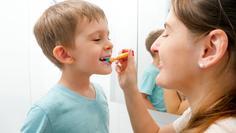 Woman brushing son’s teeth